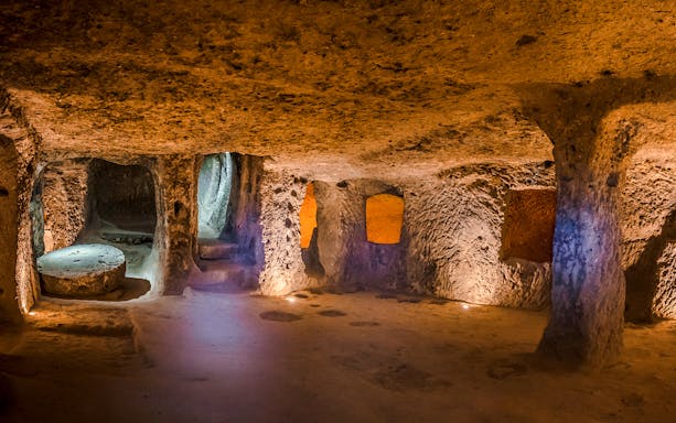 Inside view of Kaymaklı Underground City in Cappadocia, showcasing ancient carved rooms and passageways.