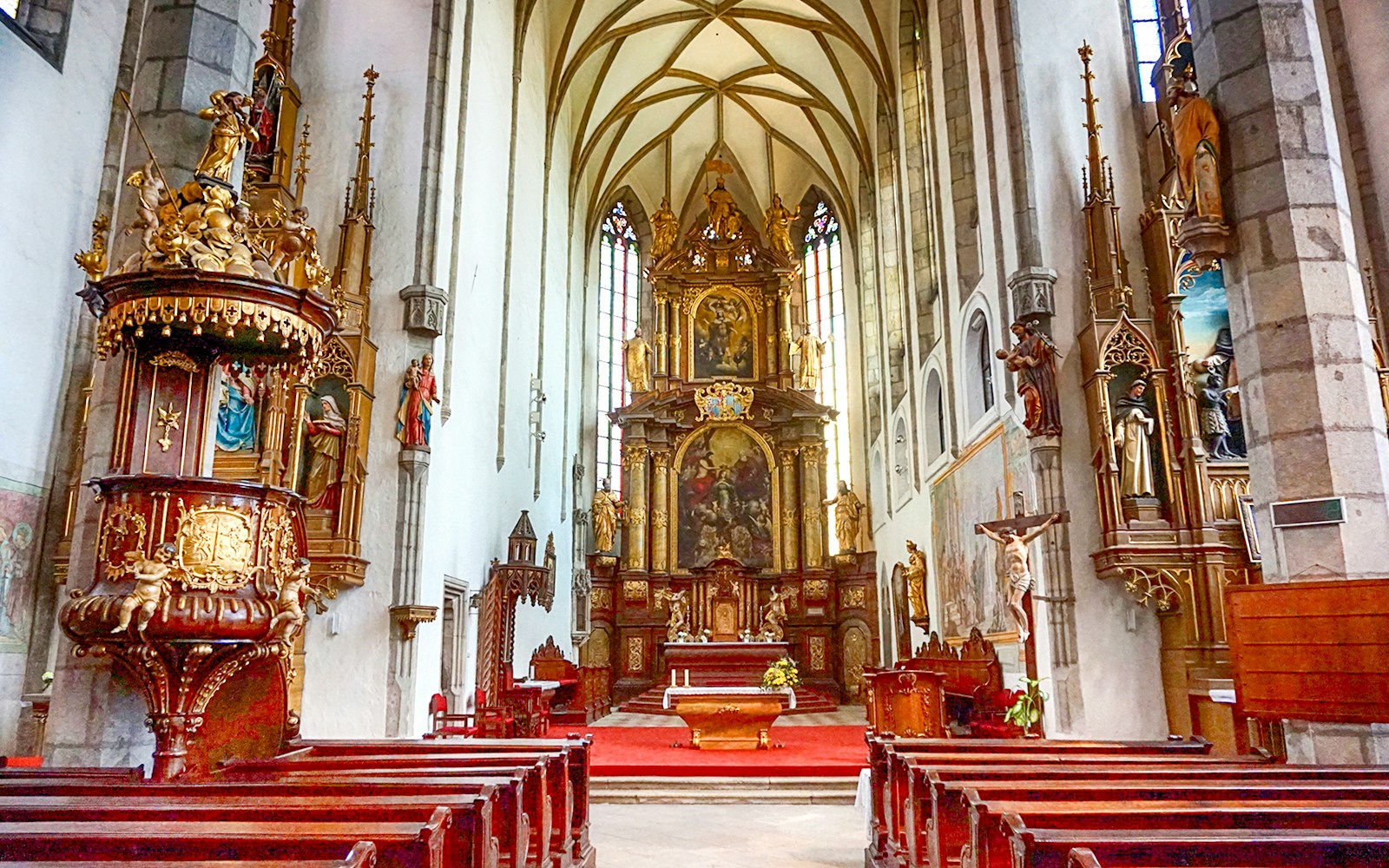 St. Vitus Cathedral interior in Cesky Krumlov with Gothic architecture and stained glass windows.