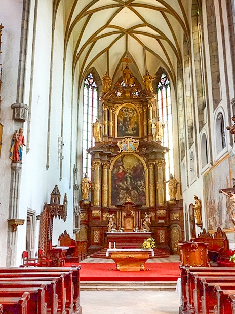 St. Vitus Cathedral interior in Cesky Krumlov with Gothic architecture and stained glass windows.