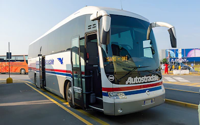 Autostradale Airport Transfer bus parked at airport terminal.