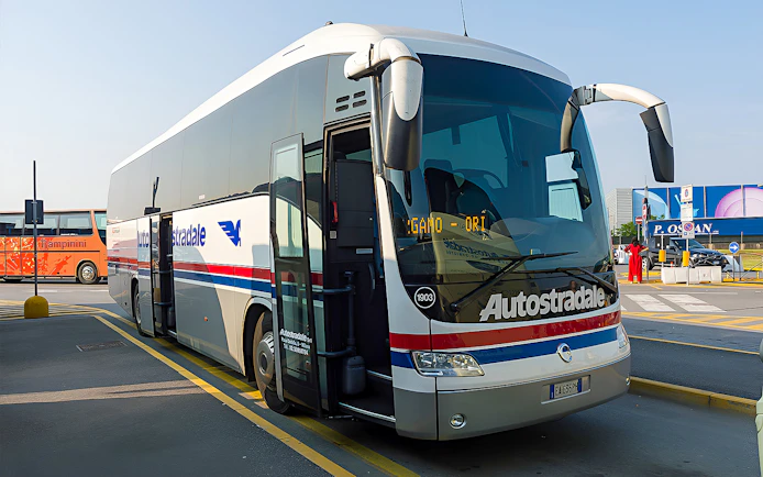Autostradale Airport Transfer bus parked at airport terminal.