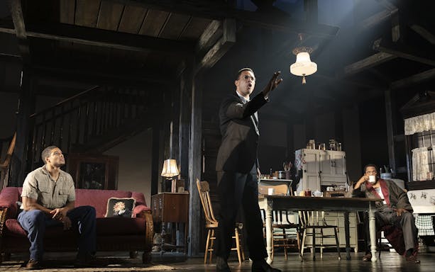 Performance scene from "The Piano Lesson" with actors in a living room setting.