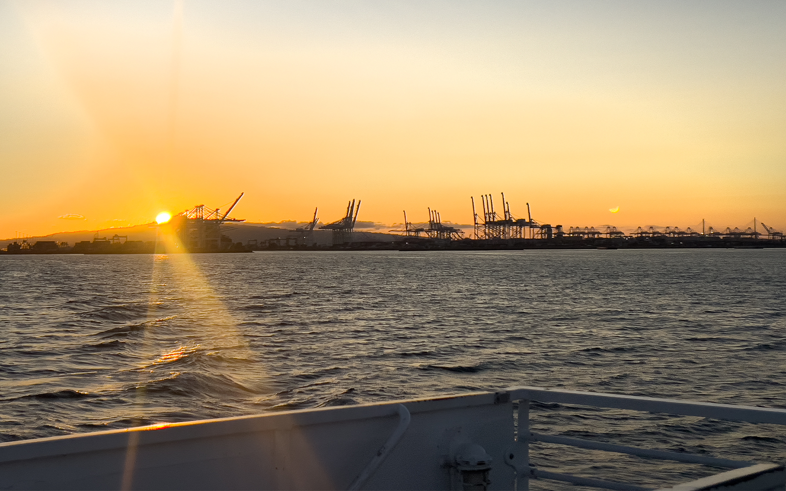 Sunset view of cranes at Los Angeles Harbor from a sightseeing cruise.