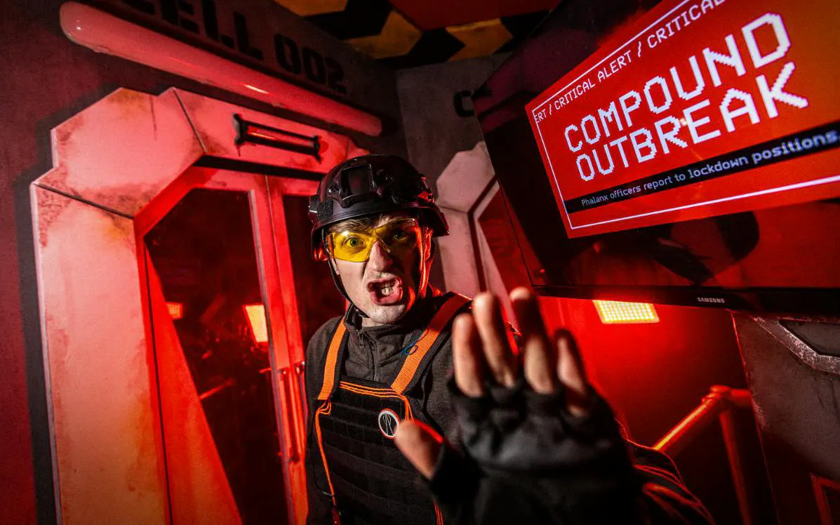 Alton Towers Scarefest actor in a horror-themed room with a warning screen.