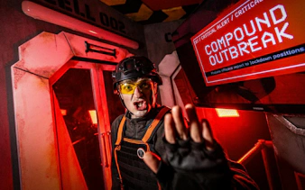 Alton Towers Scarefest actor in a horror-themed room with a warning screen.