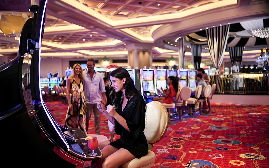 Woman celebrating at slot machine in Baha Mar Casino, Nassau, Bahamas.