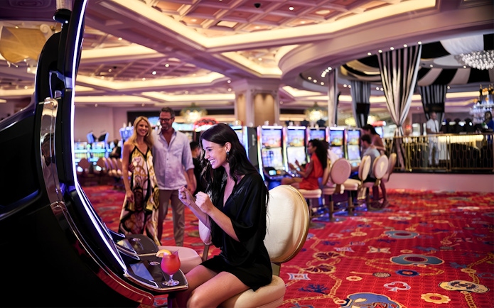 Woman celebrating at slot machine in Baha Mar Casino, Nassau, Bahamas.
