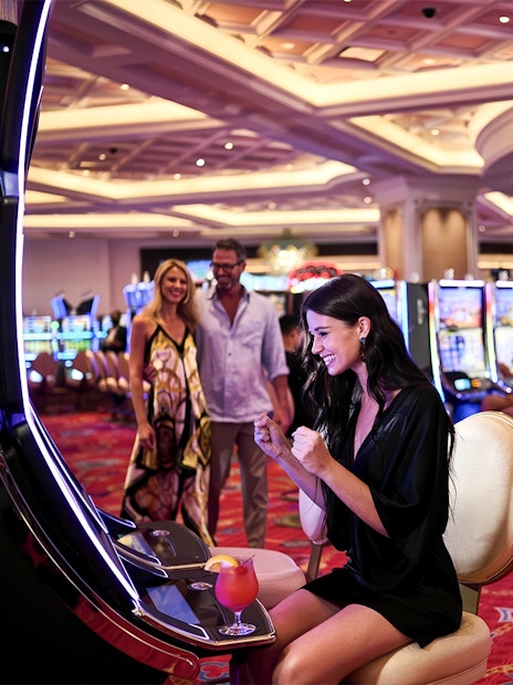 Woman celebrating at slot machine in Baha Mar Casino, Nassau, Bahamas.