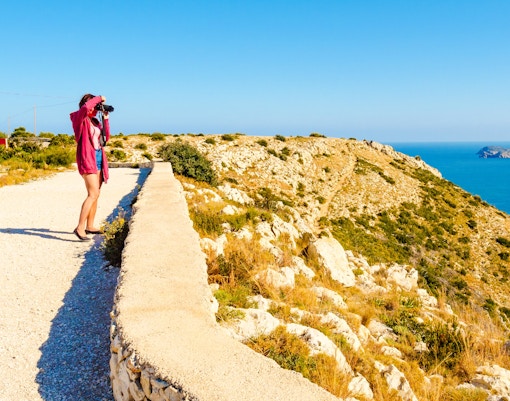 Tourist photographing coastal landscape at Cape, San Antonio, Texas.