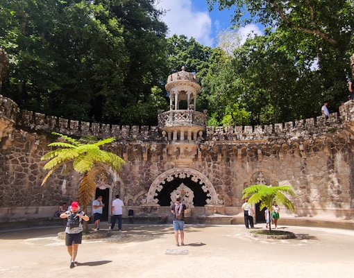 Quinta da Regaleira palace courtyard with tourists during a guided tour in Sintra.