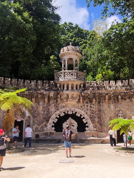 Quinta da Regaleira palace courtyard with tourists during a guided tour in Sintra.