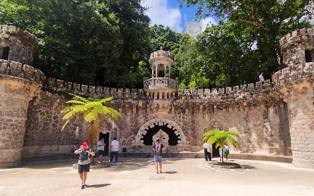 Quinta da Regaleira palace courtyard with tourists during a guided tour in Sintra.