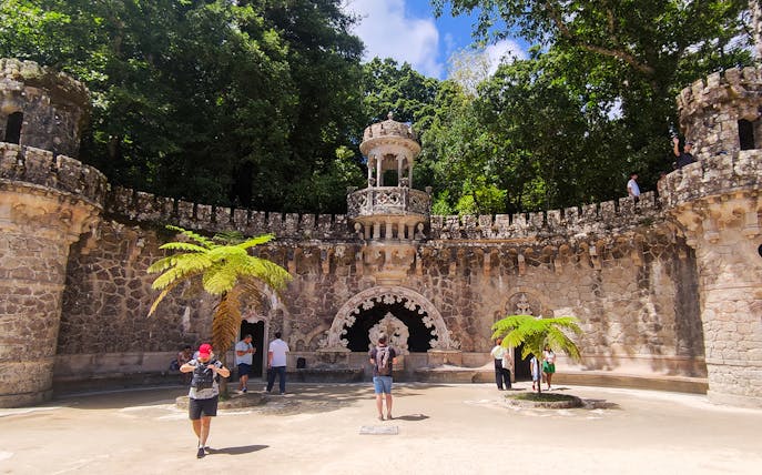 Quinta da Regaleira palace courtyard with tourists during a guided tour in Sintra.