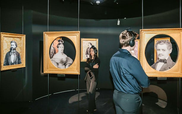 Visitors viewing portraits at the Johann Strauss Museum in Vienna.