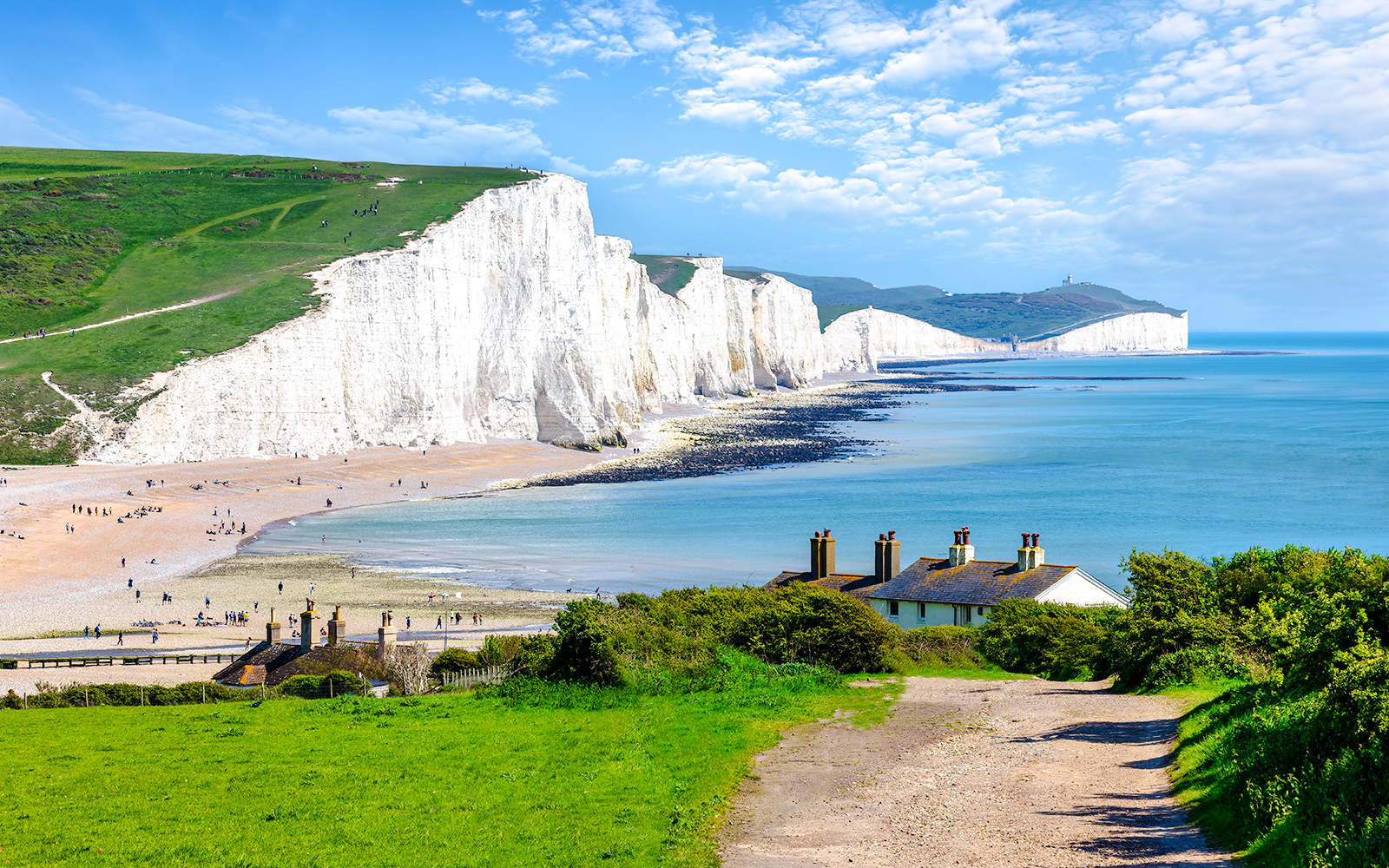Seven Sisters Chalk Cliffs overlooking the English Channel with coastal path and cottages.