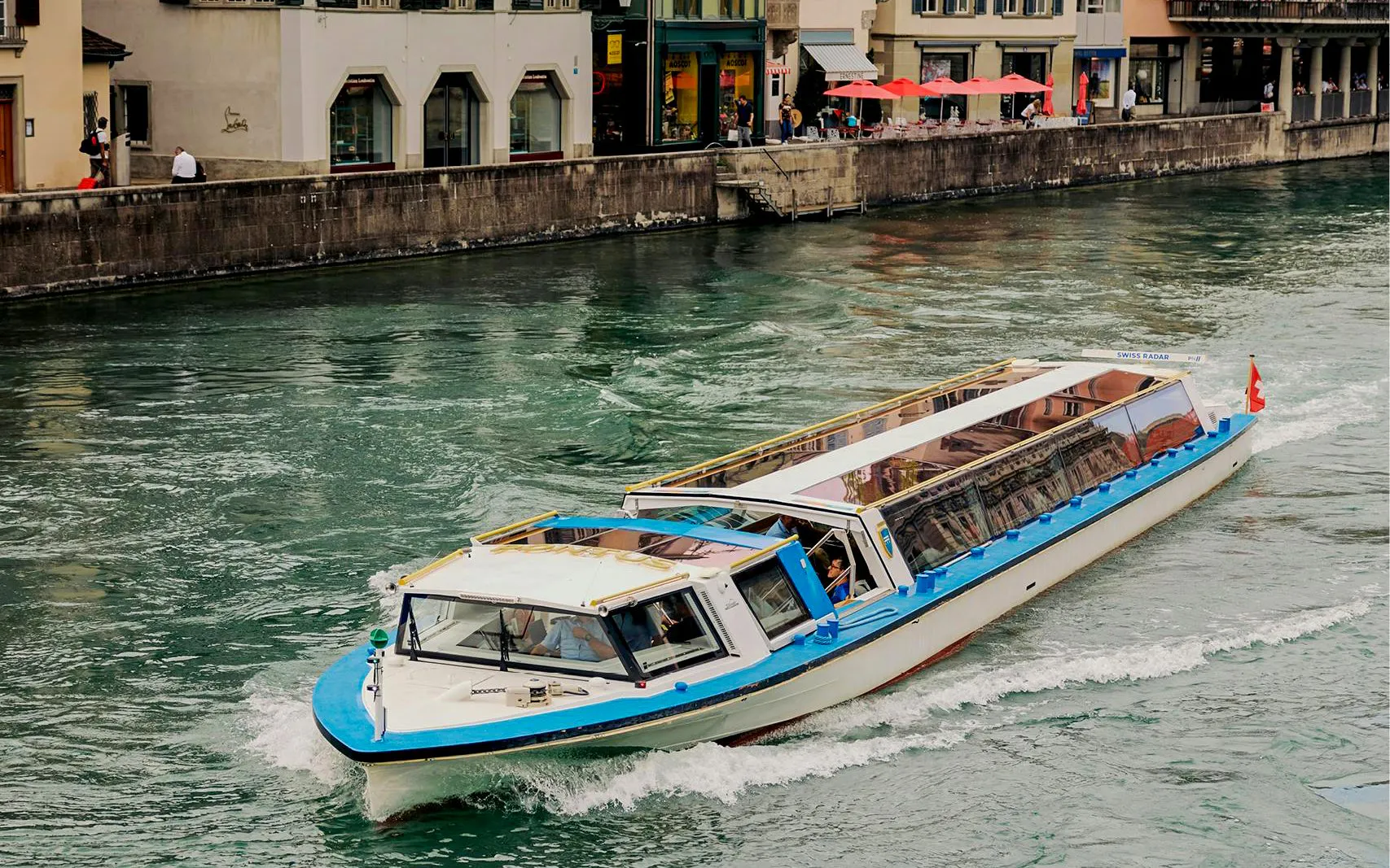 Zurich canal cruise boat navigating through city waterway.