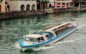 Zurich canal cruise boat navigating through city waterway.