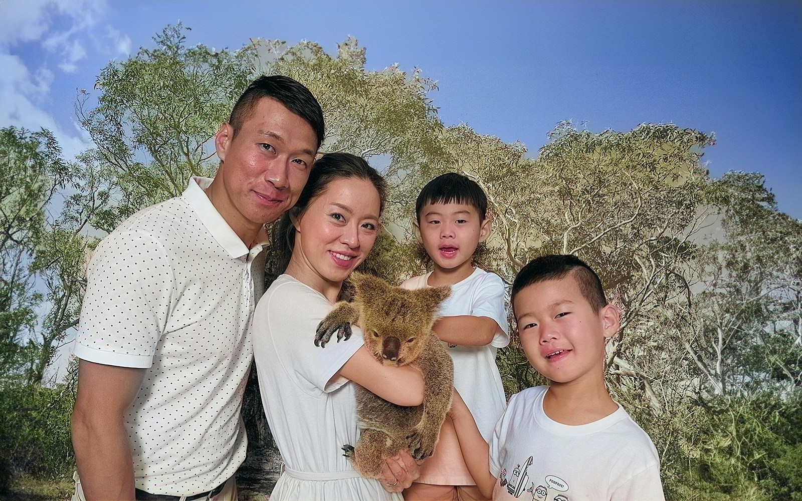 Family holding a koala at Kuranda Koala Gardens, Australia.