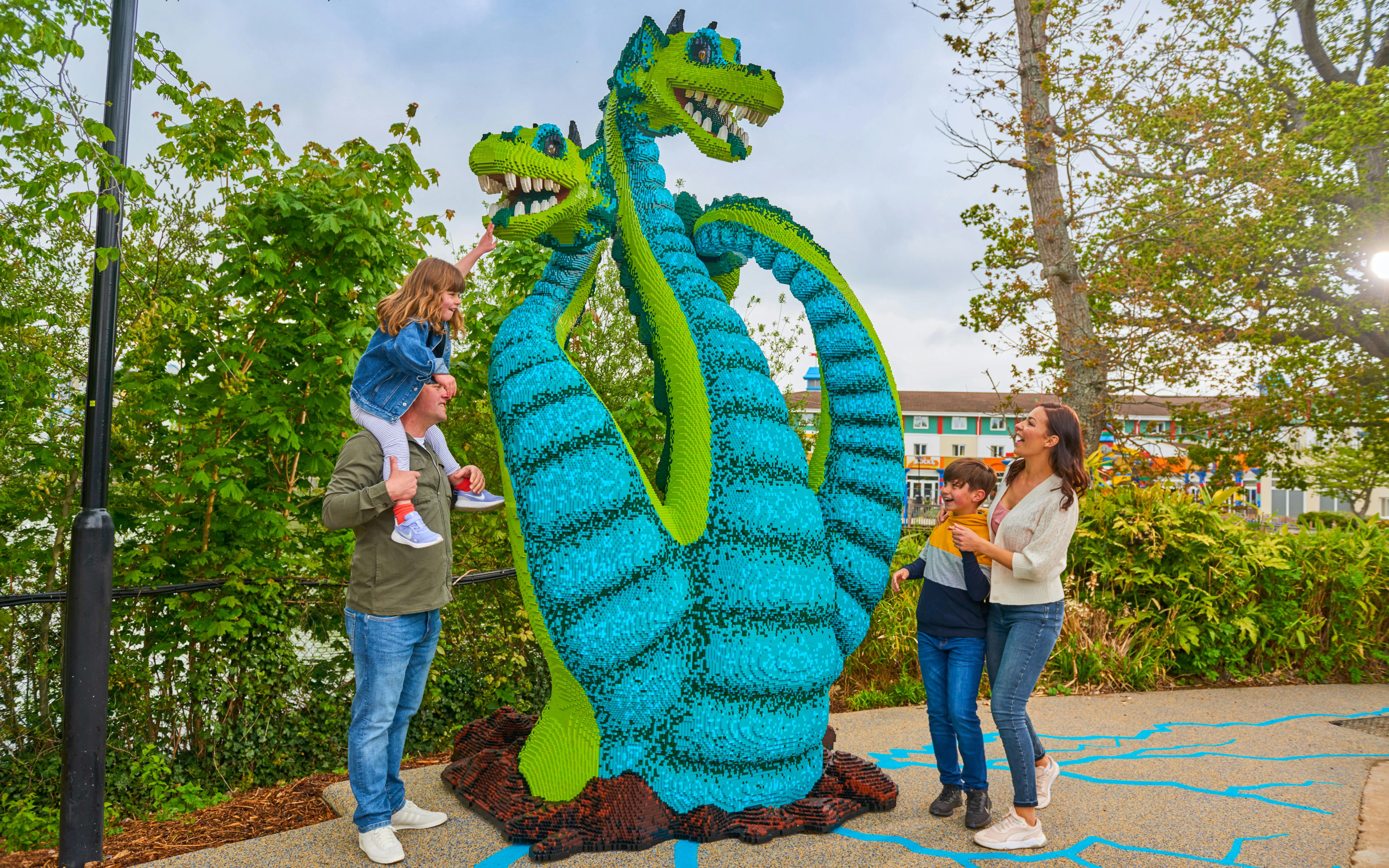 Family enjoying a Lego hydra sculpture at Legoland Windsor.