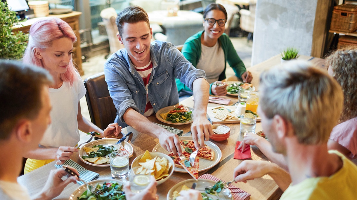 Group of friends enjoying Italian pizza at a restaurant.