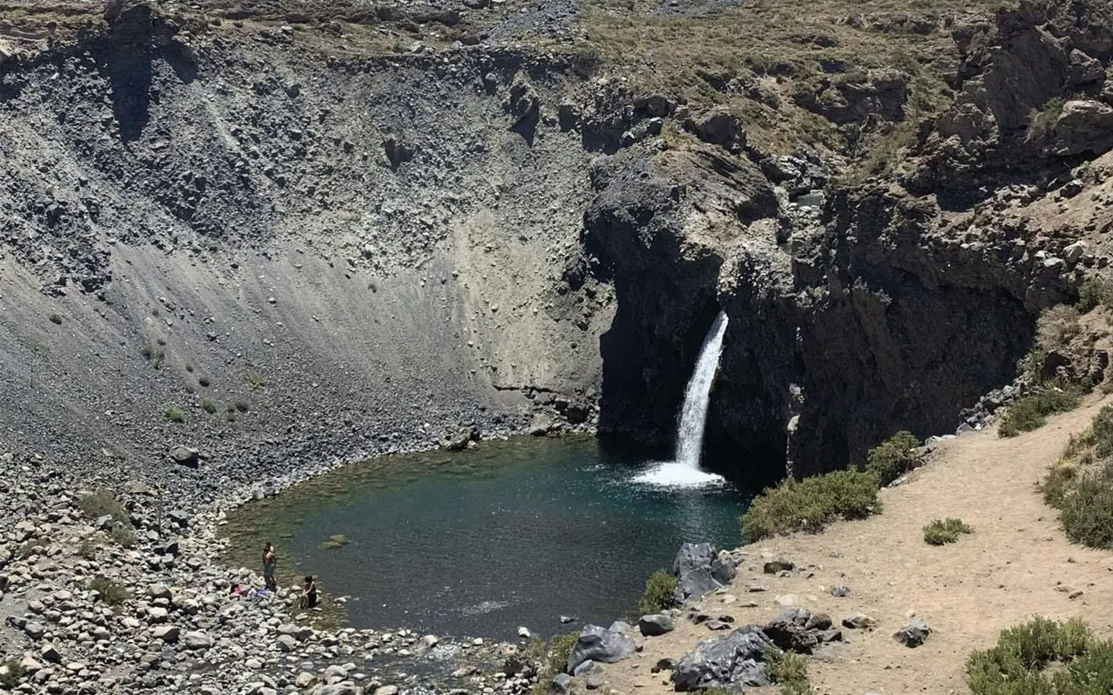 Waterfall flowing into a rocky pool at Cajon del Maipo, Santiago.