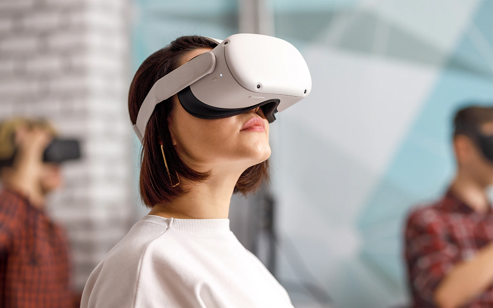 Person wearing VR goggles in a modern indoor setting.