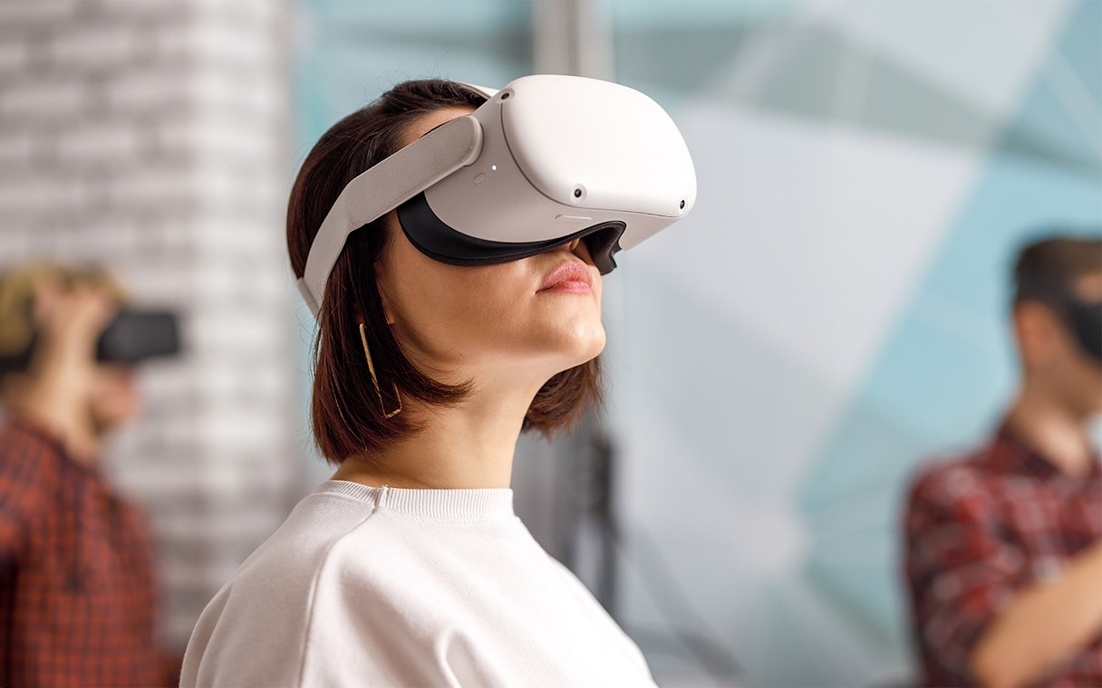 Person wearing VR goggles in a modern indoor setting.