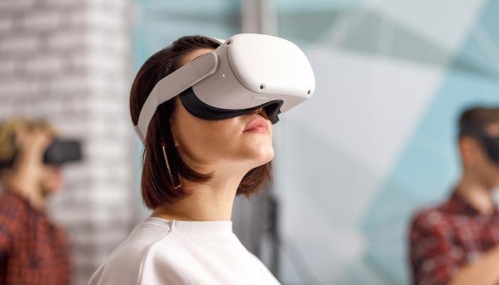 Person wearing VR goggles in a modern indoor setting.