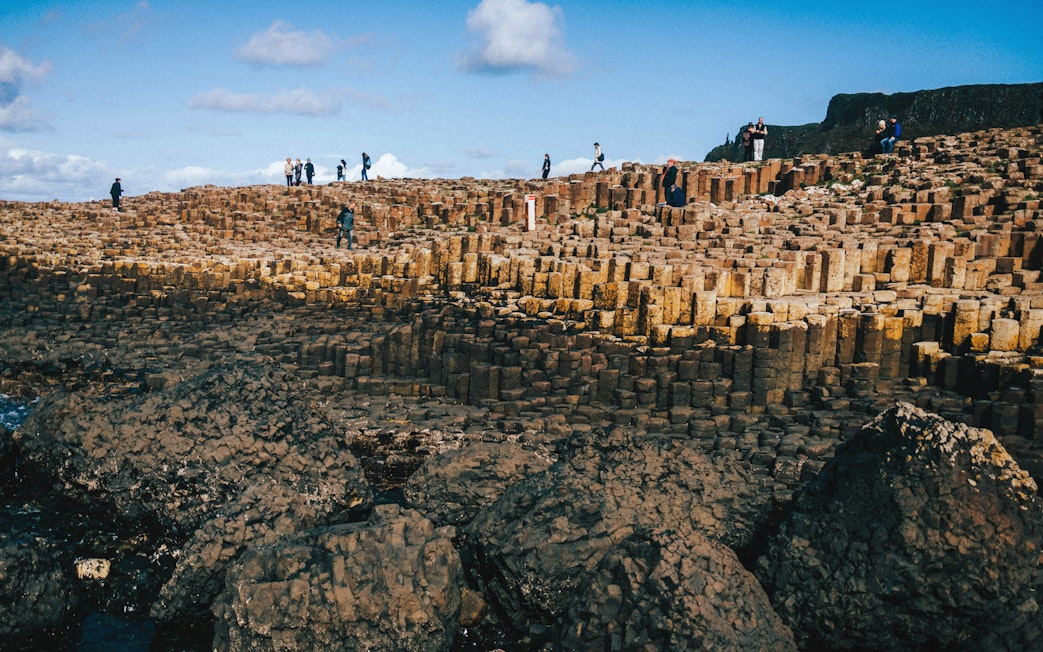 Tourists exploring the basalt columns at Giant's Causeway, Northern Ireland.
