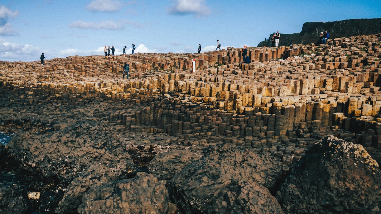 Tourists exploring the basalt columns at Giant's Causeway, Northern Ireland.