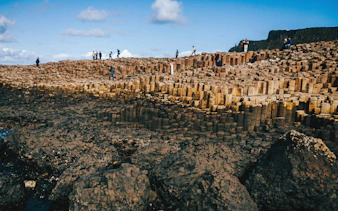 Tourists exploring the basalt columns at Giant's Causeway, Northern Ireland.
