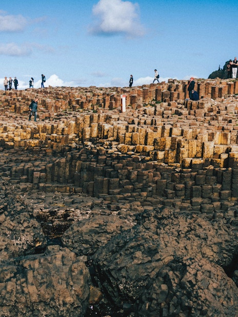 Tourists exploring the basalt columns at Giant's Causeway, Northern Ireland.