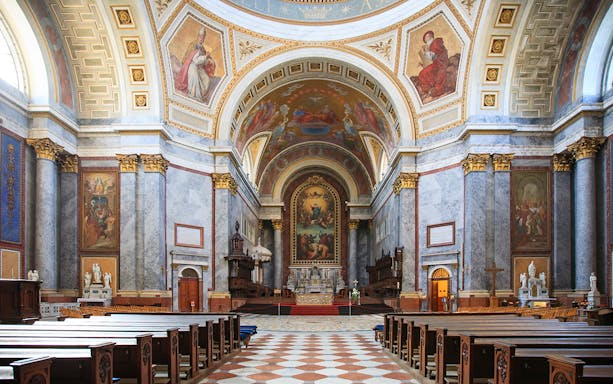 Interior view of the Basilica of St. Adalbert in Esztergom, featuring ornate frescoes and grand architecture.