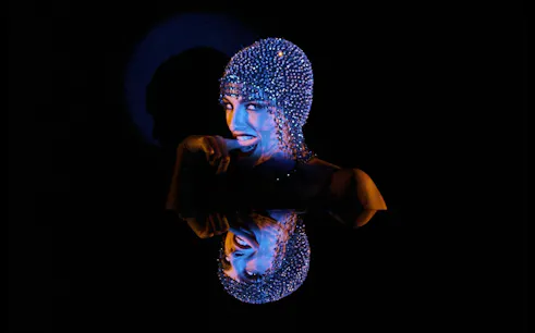 Performer in sparkling headpiece at Crazy Horse Paris - The Dubai Edition, Dubai.