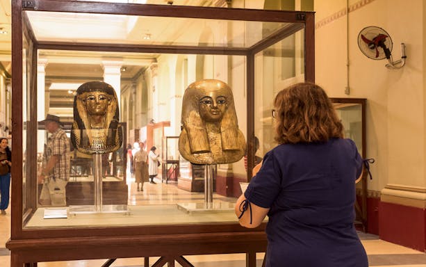 Visitor viewing ancient Egyptian masks at the Egyptian Museum in Cairo.