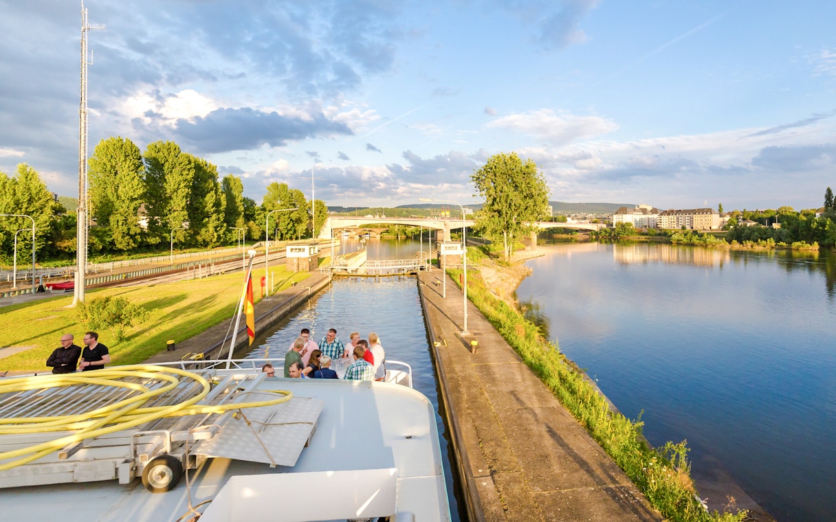 Koblenz river cruise with passengers enjoying scenic views of the Rhine and Moselle confluence.