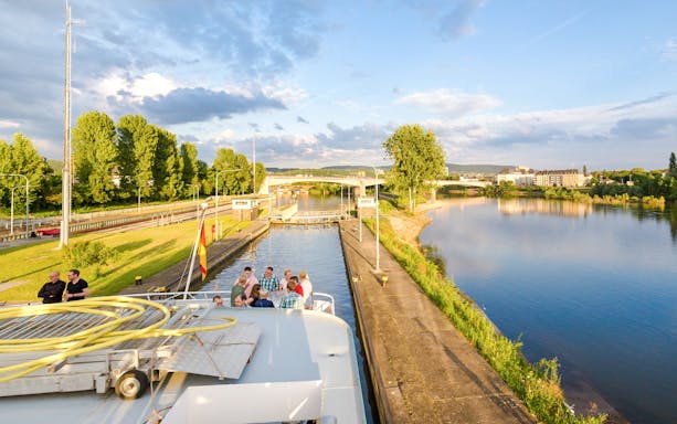 Koblenz river cruise with passengers enjoying scenic views of the Rhine and Moselle confluence.