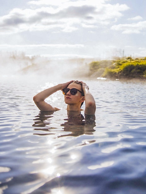 Guests enjoying geothermal waters at Secret Lagoon Gamla Laugin, Iceland.