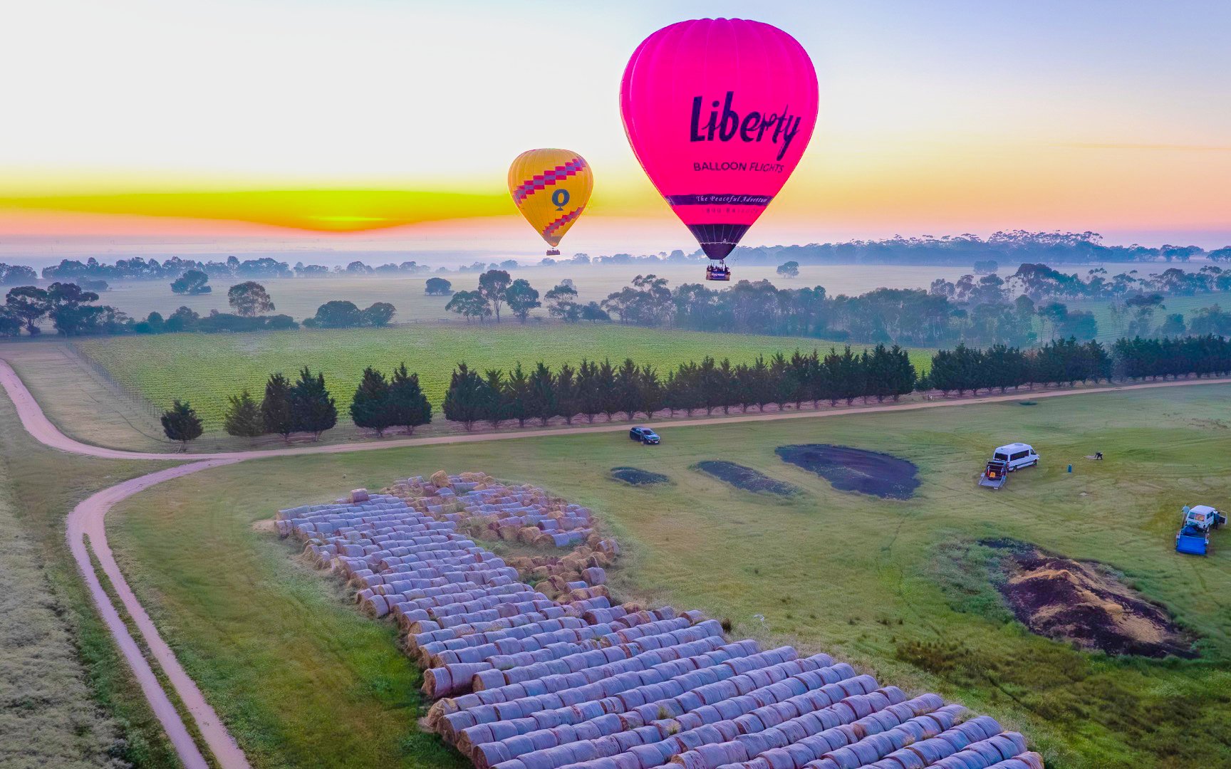 Hot air balloons over fields at sunrise, Liberty Balloon Flights, Geelong and Bellarine, Australia.