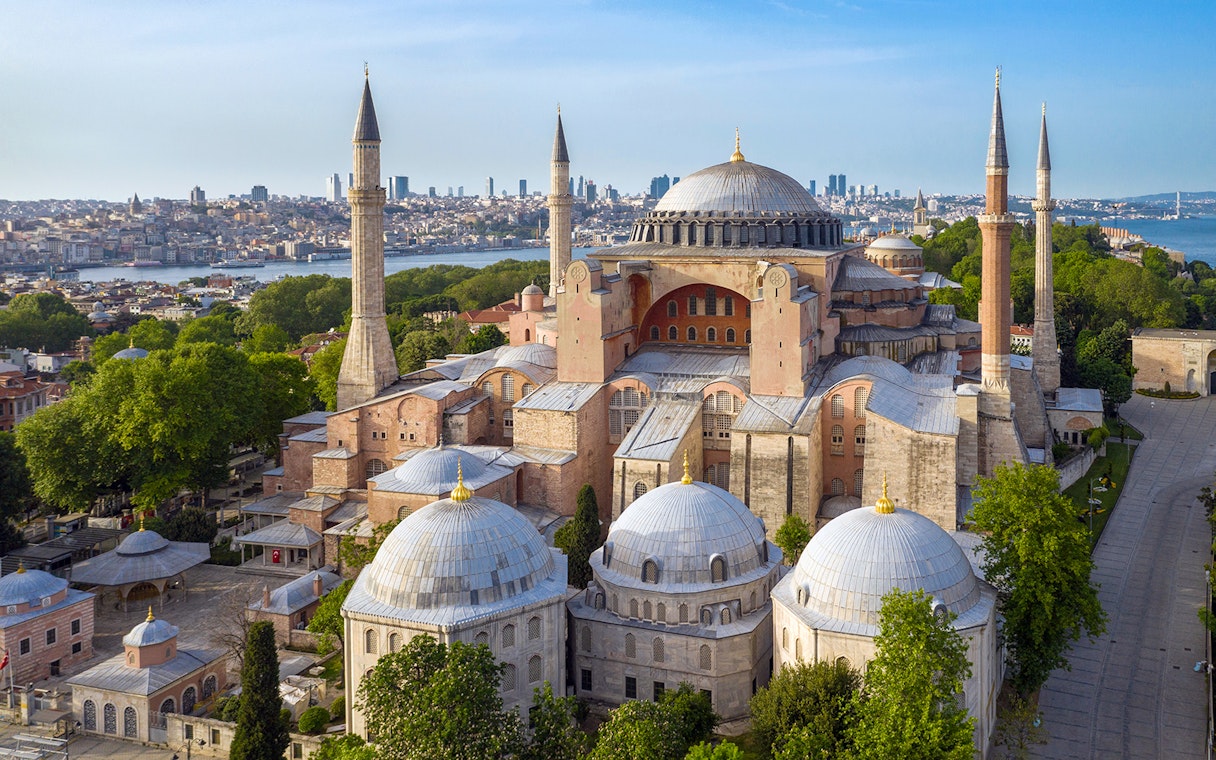 Hagia Sophia in Istanbul with minarets and city skyline in the background.