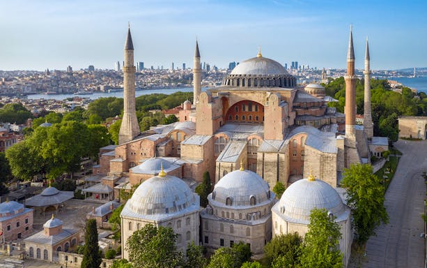 Hagia Sophia in Istanbul with minarets and city skyline in the background.