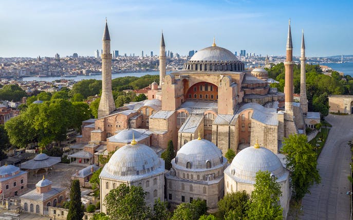 Hagia Sophia in Istanbul with minarets and city skyline in the background.