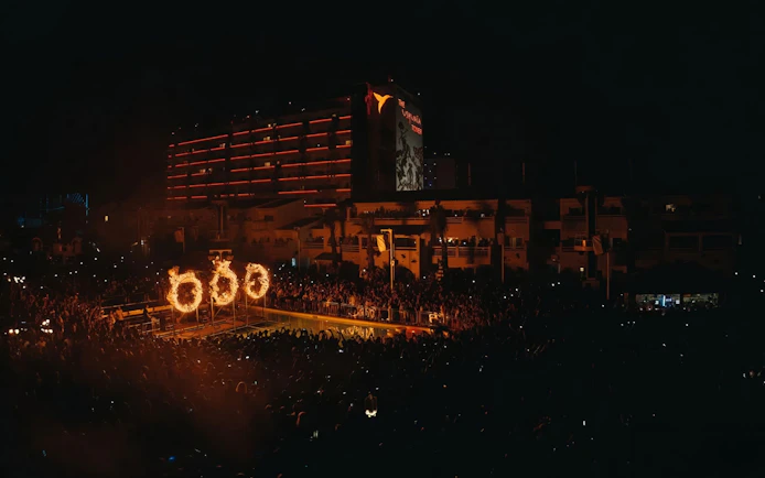 Crowd at Swedish House Mafia performance with fiery stage effects at Ushuaïa, Ibiza.