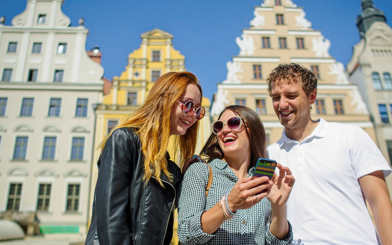 Tourists enjoying Wroclaw's colorful market square during a small-group tour from Warsaw.