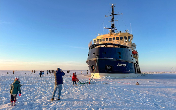 Icebreaker Arktis on frozen sea with tourists, Kemi cruise experience.