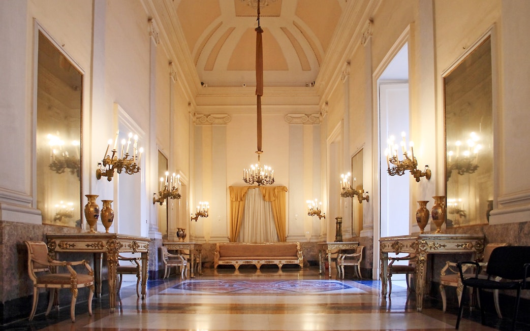 Royal Palace of Naples historic apartment with chandeliers and ornate furniture.