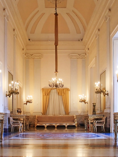 Royal Palace of Naples historic apartment with chandeliers and ornate furniture.