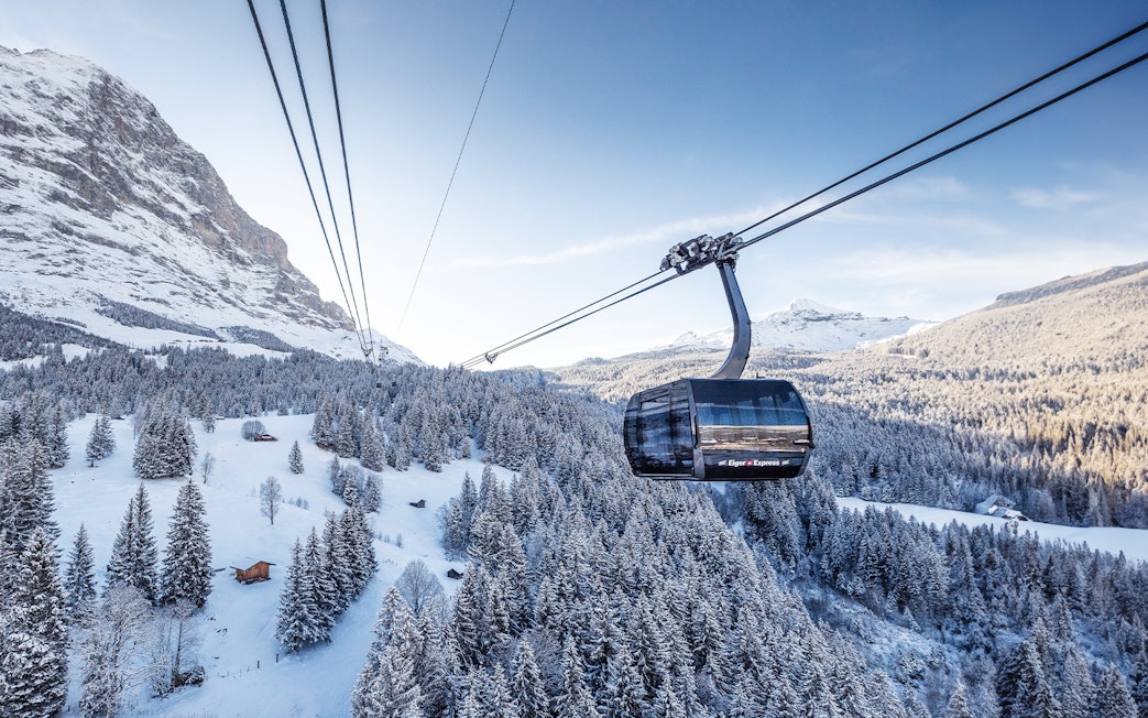 Cable car over snowy Swiss Alps landscape with Jungfrau Travel Pass.