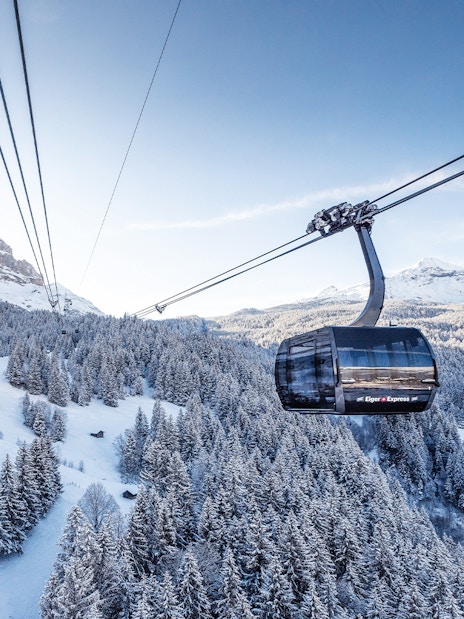 Cable car over snowy Swiss Alps landscape with Jungfrau Travel Pass.