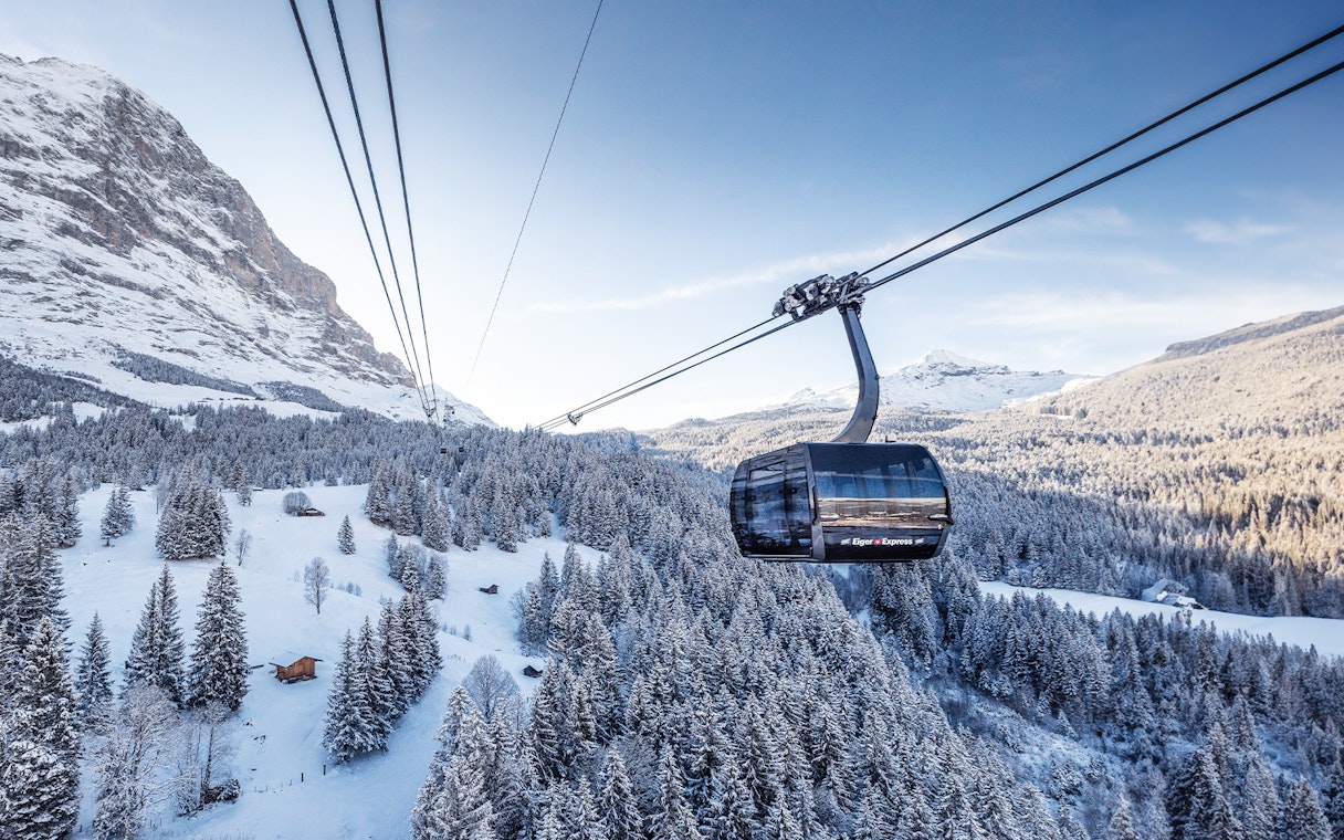 Cable car over snowy Swiss Alps landscape with Jungfrau Travel Pass.